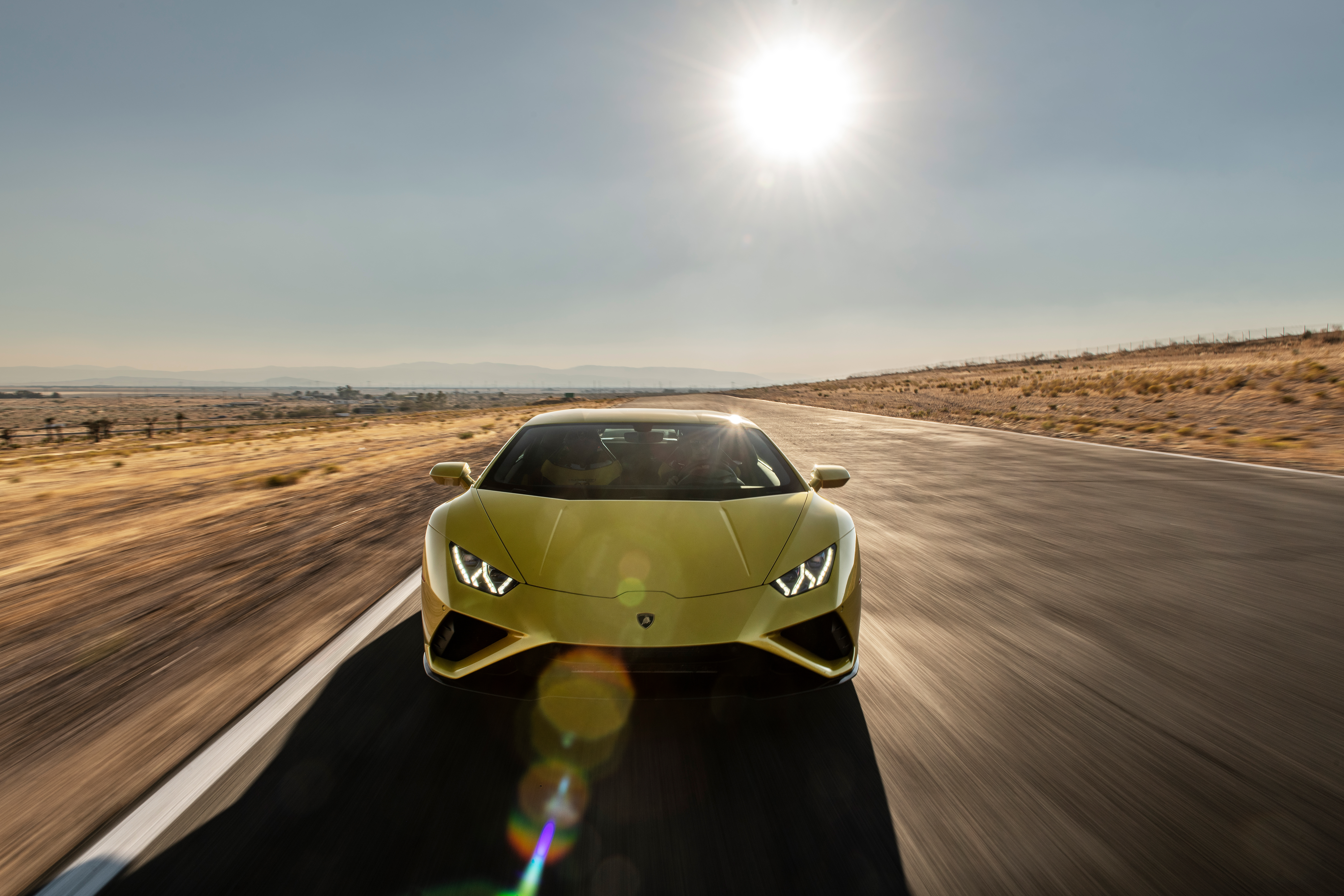 Yellow Lamborghini Huracan driving on a desert road HD Wallpaper