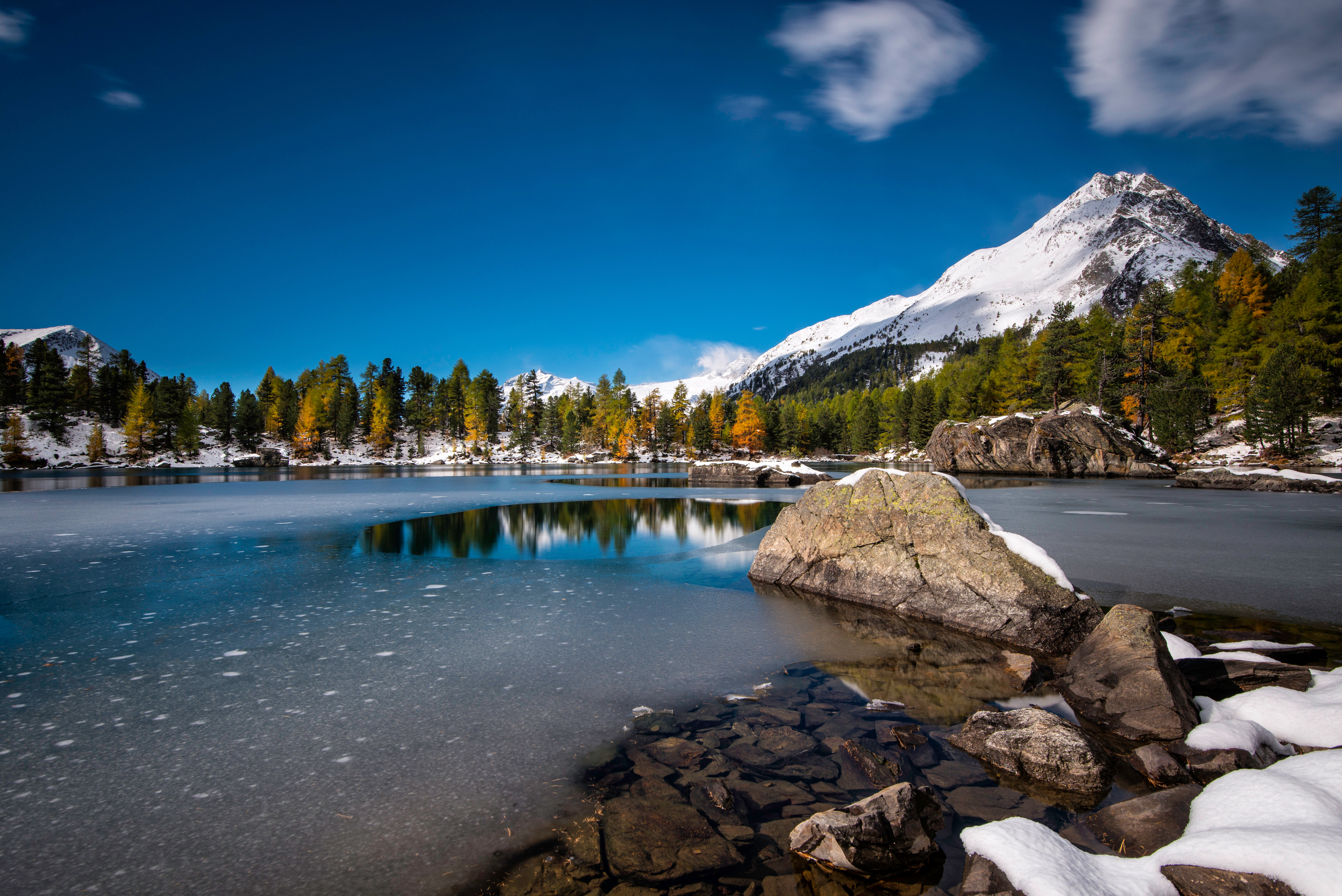 Frozen lake with autumn trees and snow-capped mountains HD Wallpaper