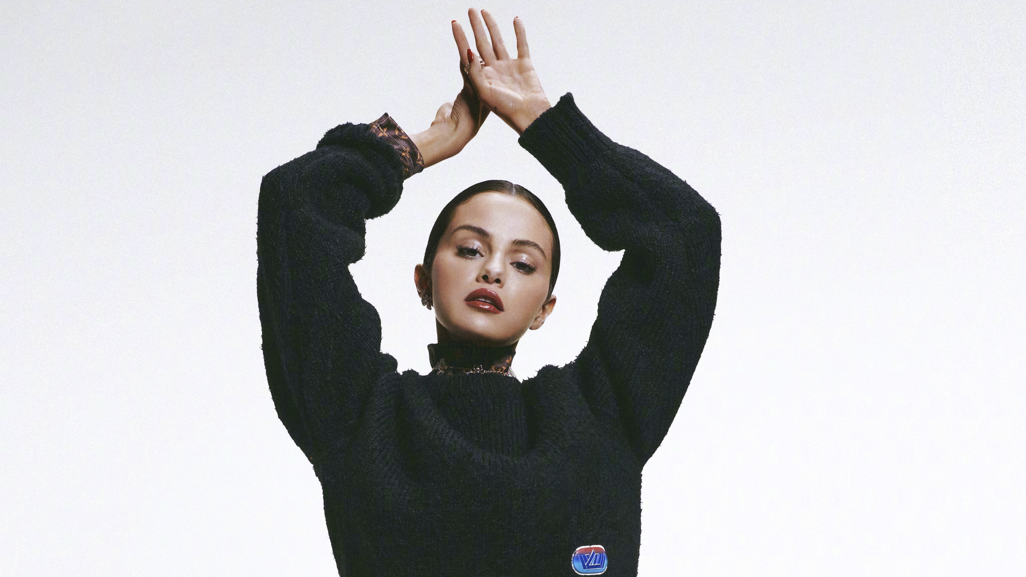 Selena Gomez posing in a black sweater HD Wallpaper