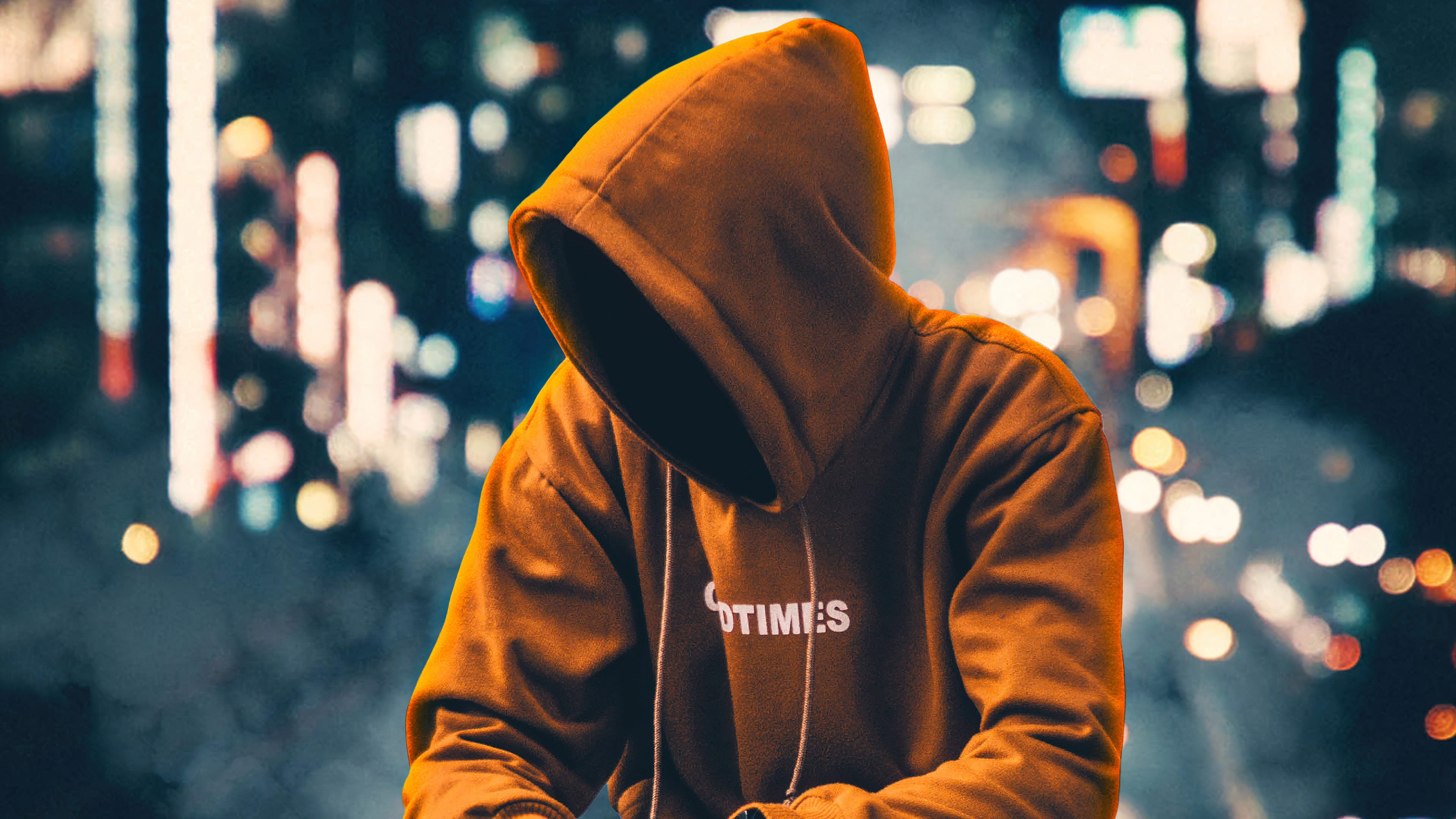 Anonymous Figure in Orange Hoodie at Night HD Wallpaper