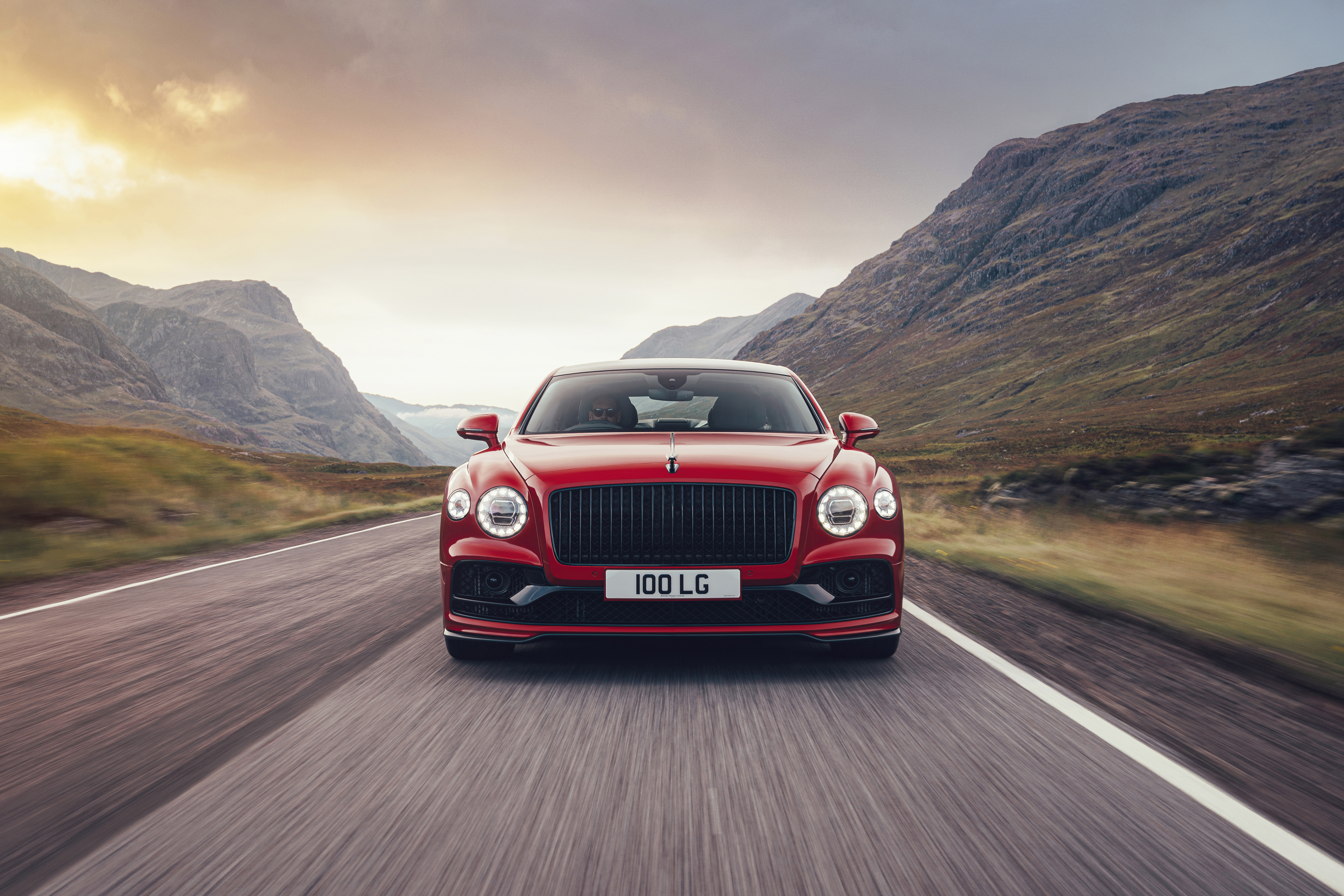 Red Bentley Flying Spur driving on a mountain road HD Wallpaper