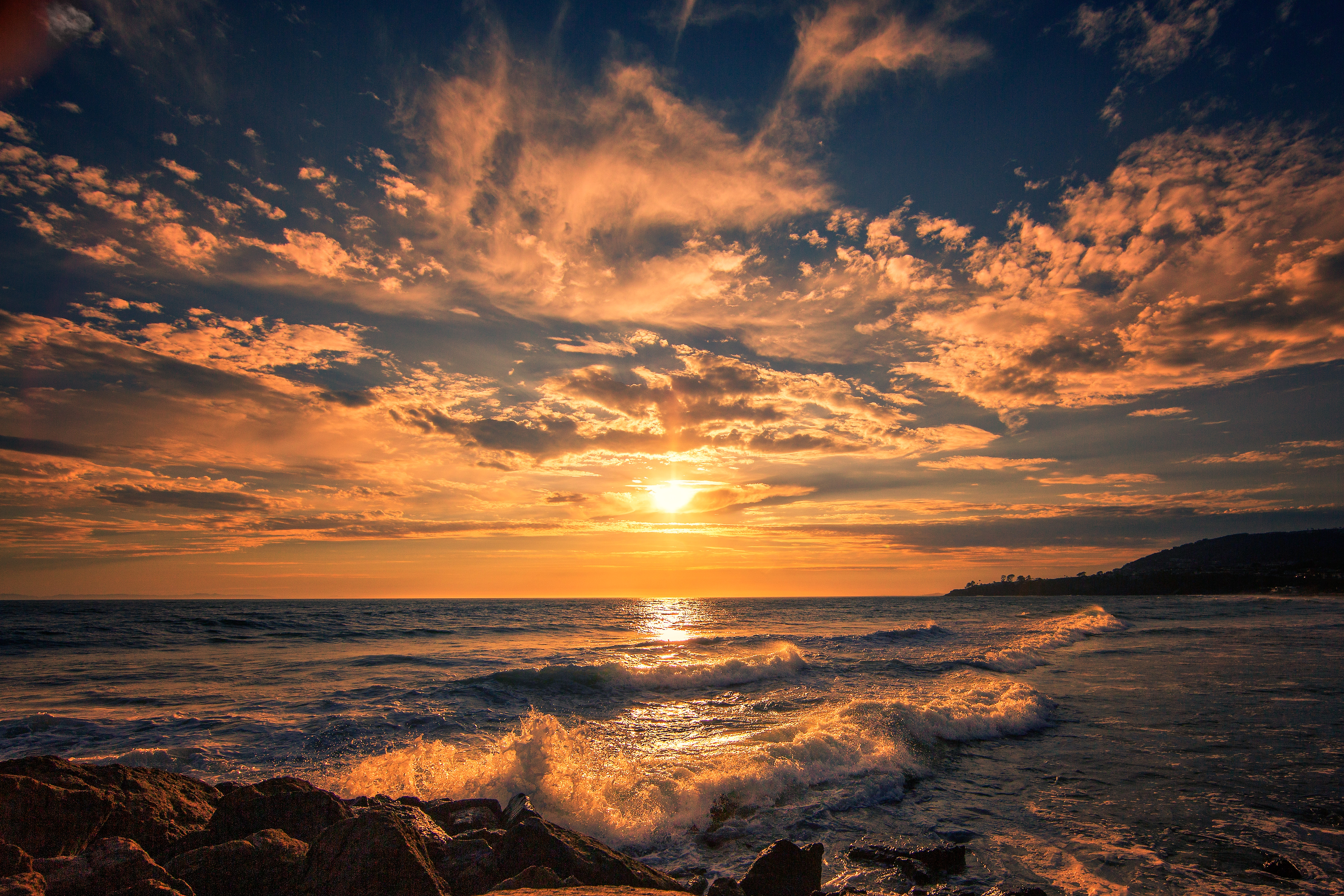 Sunset over the ocean with waves and rocks HD Wallpaper