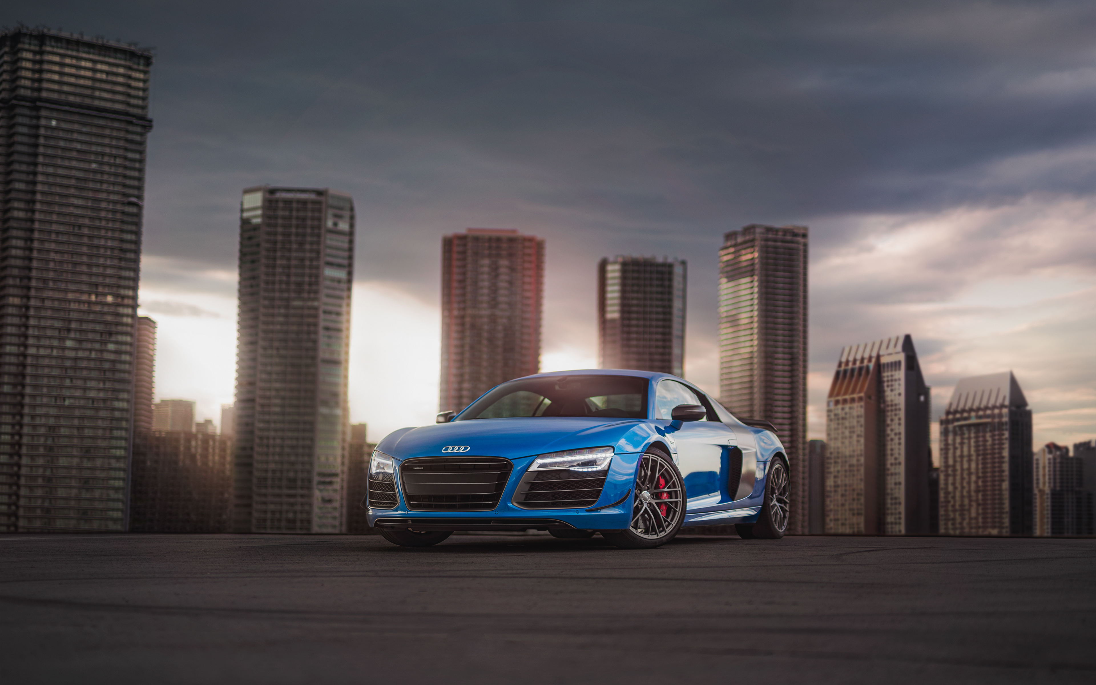 Blue Audi R8 in front of city skyline HD Wallpaper