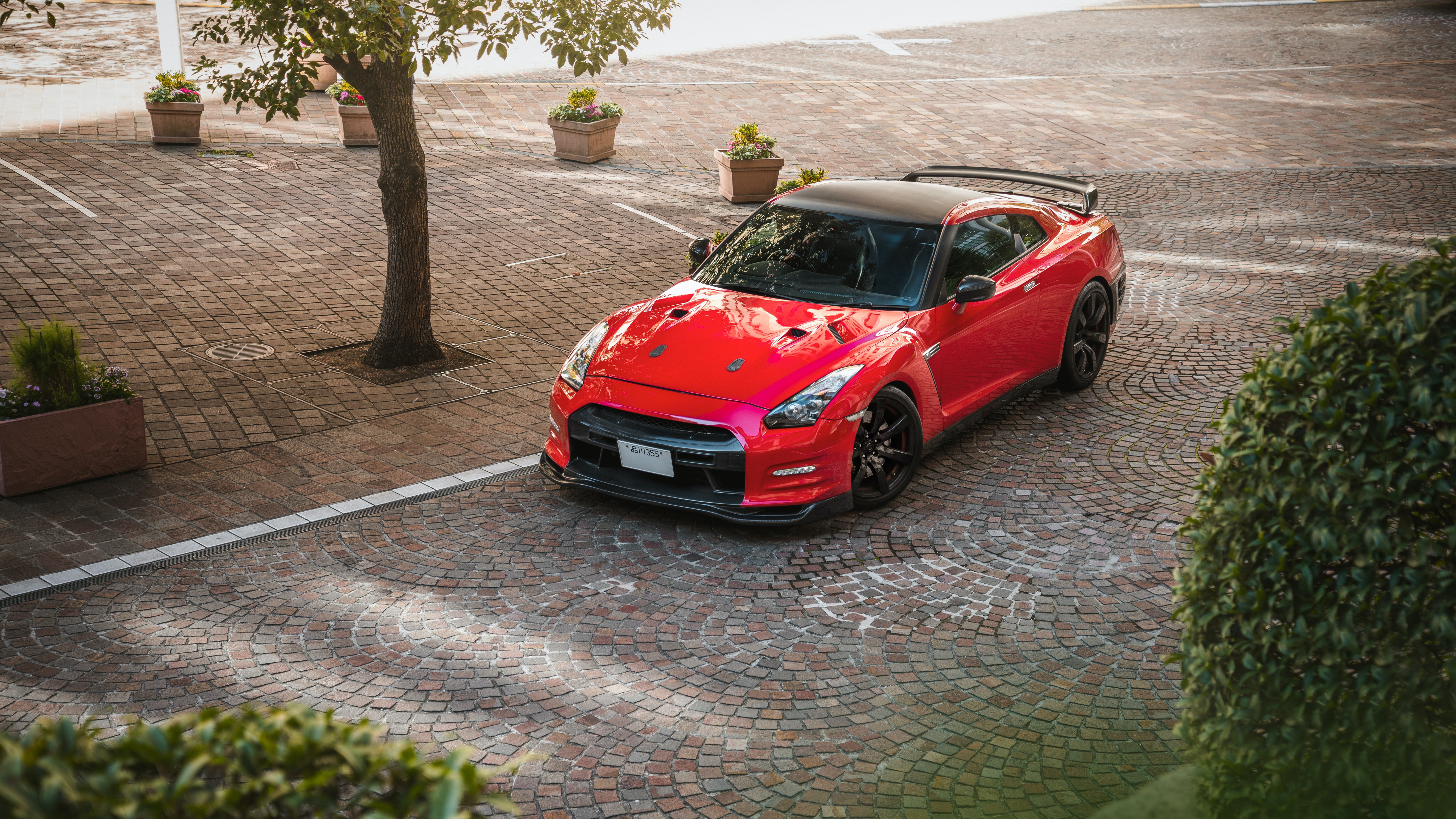 Red Nissan GT-R parked on cobblestone HD Wallpaper