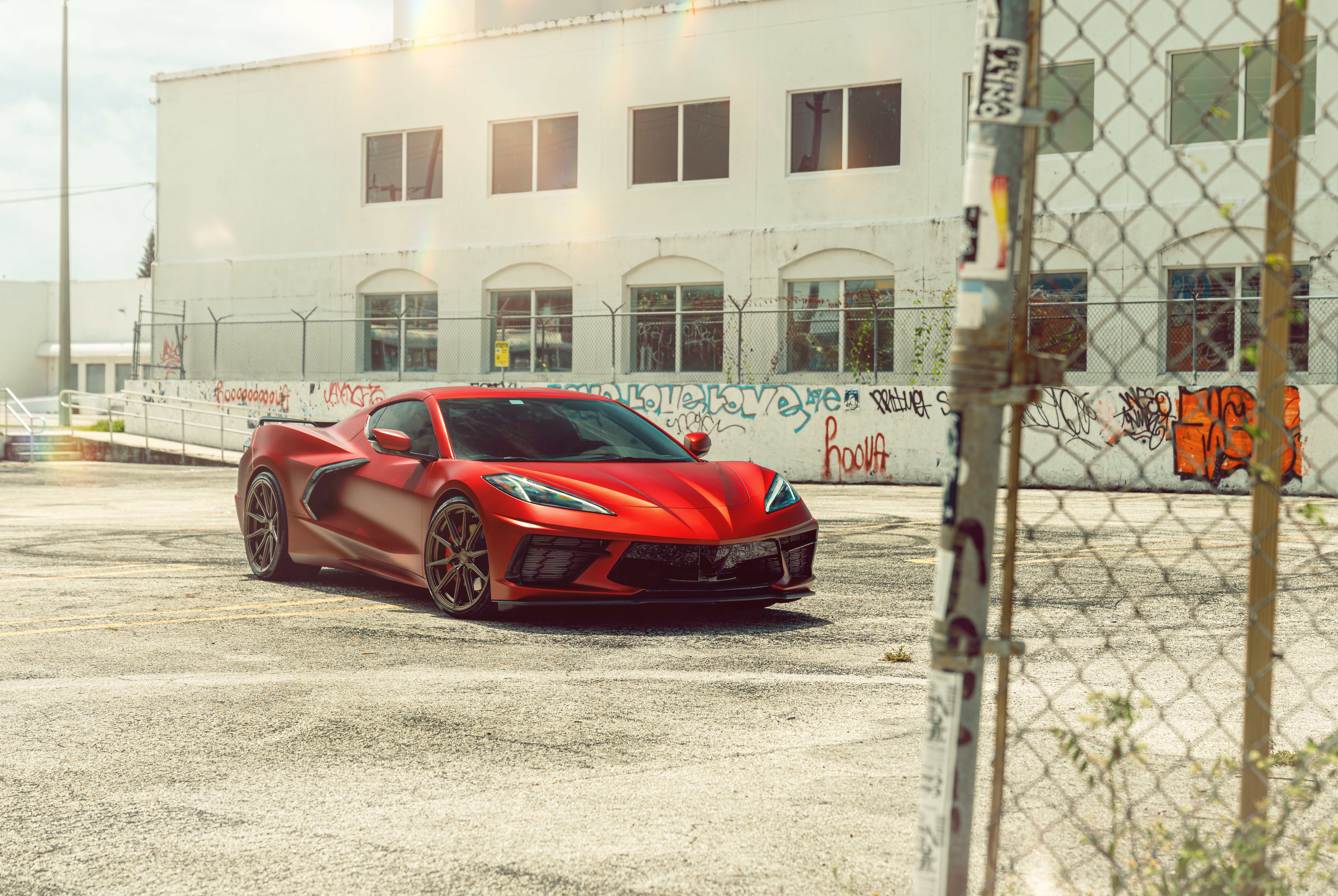 Red Chevrolet Corvette Stingray C8 parked near graffiti wall HD Wallpaper