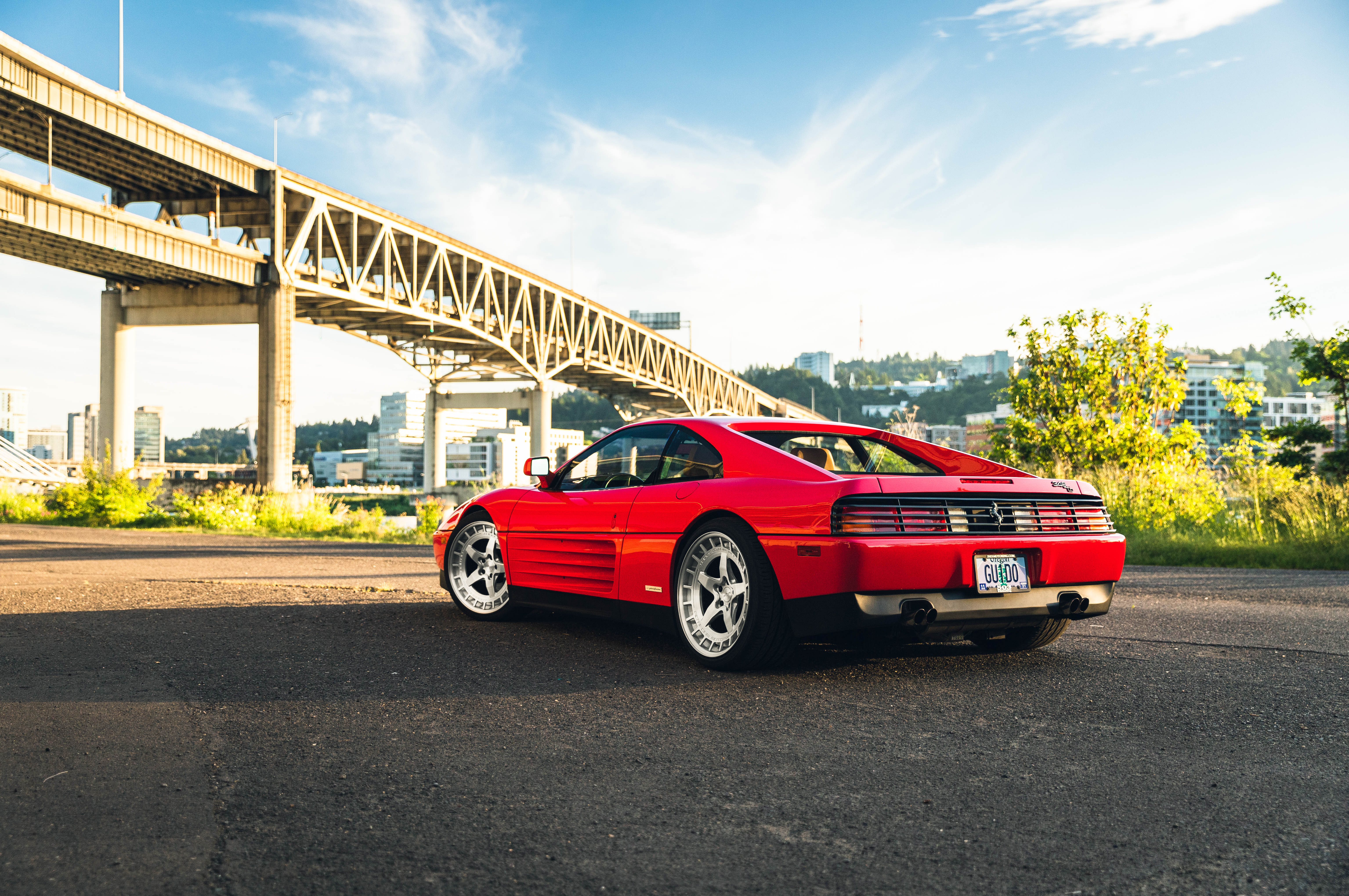 Red Ferrari 348 parked near a bridge HD Wallpaper