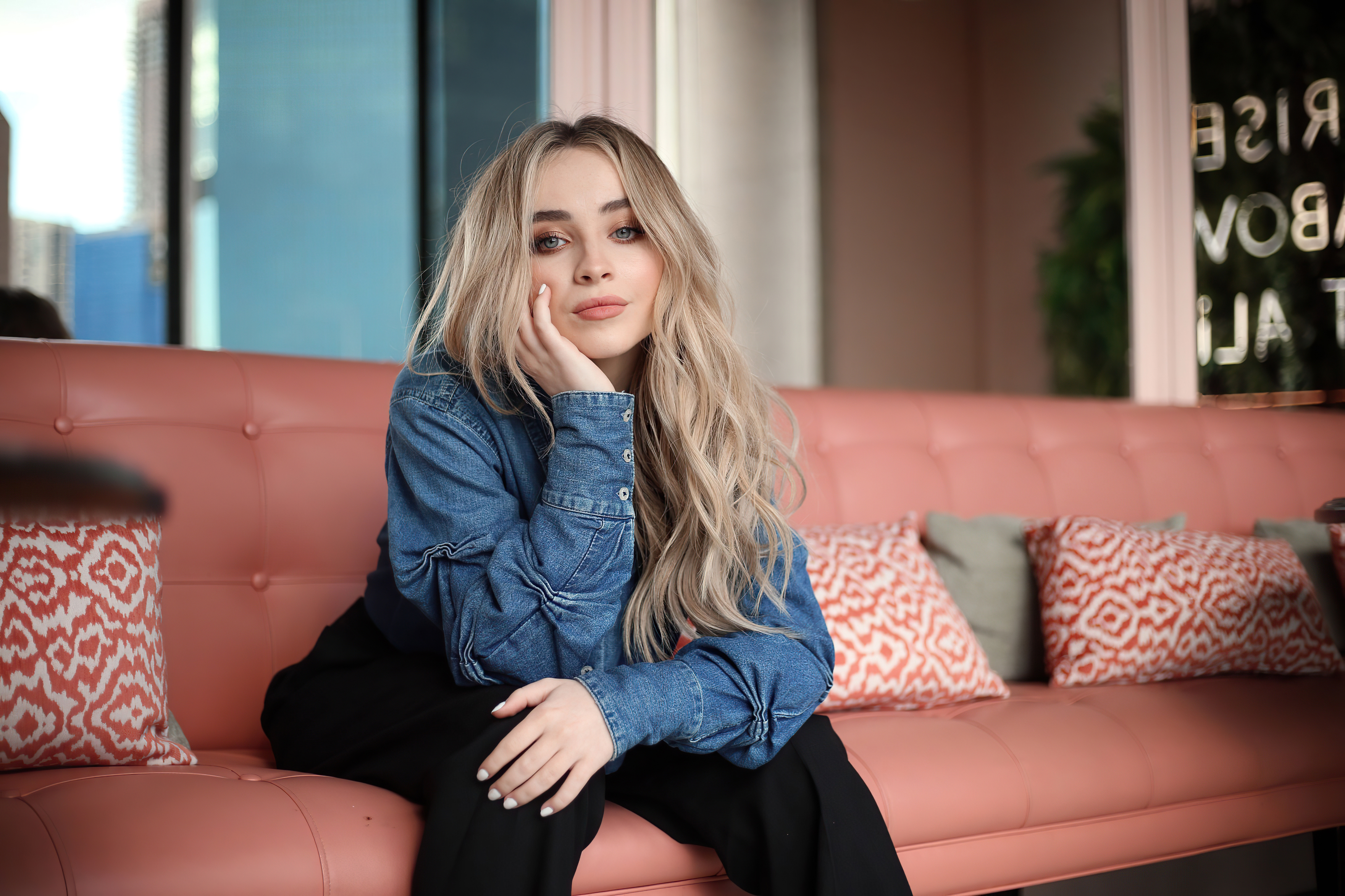 Sabrina Carpenter sitting on a pink couch HD Wallpaper