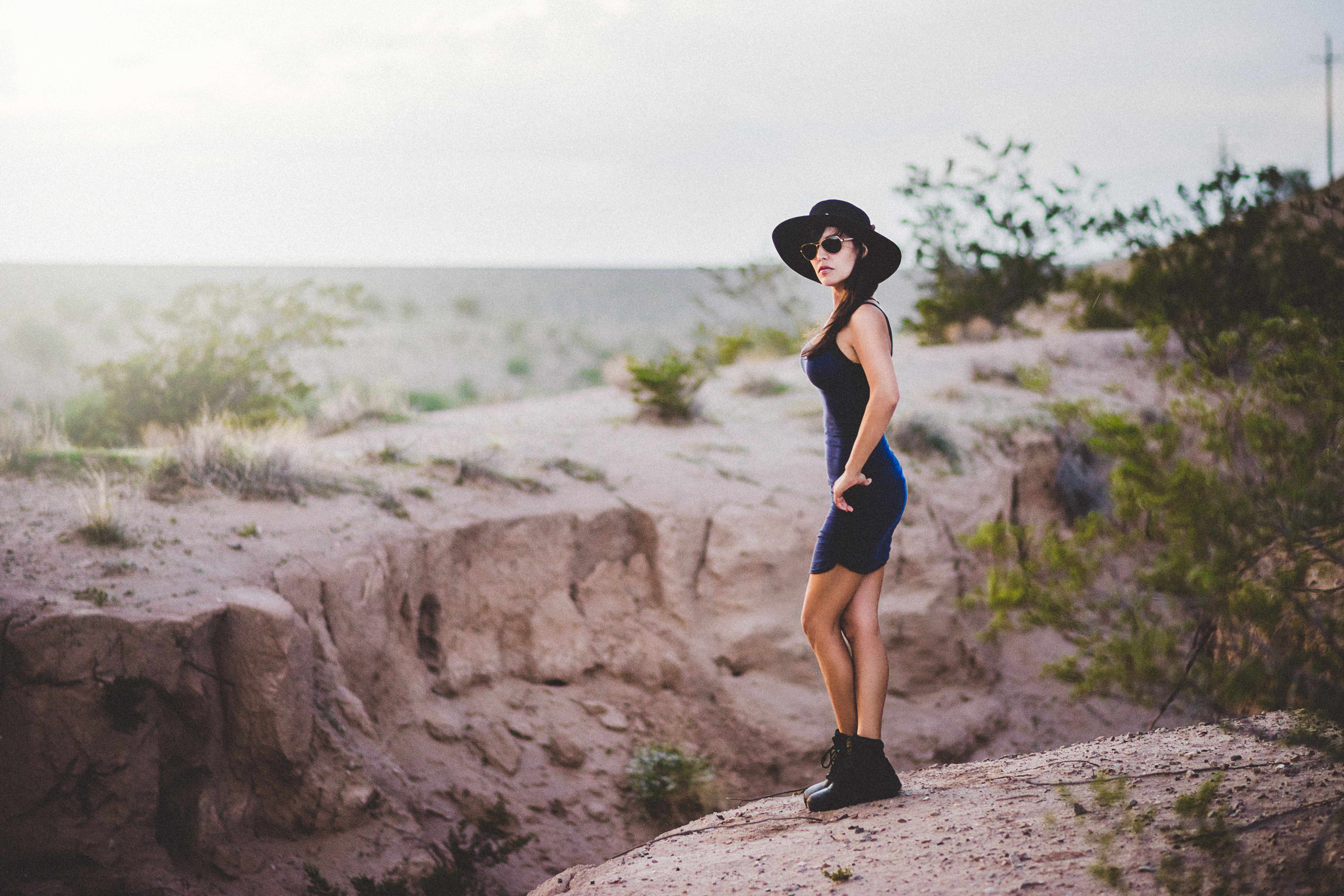Woman in hat and sunglasses in desert HD Wallpaper