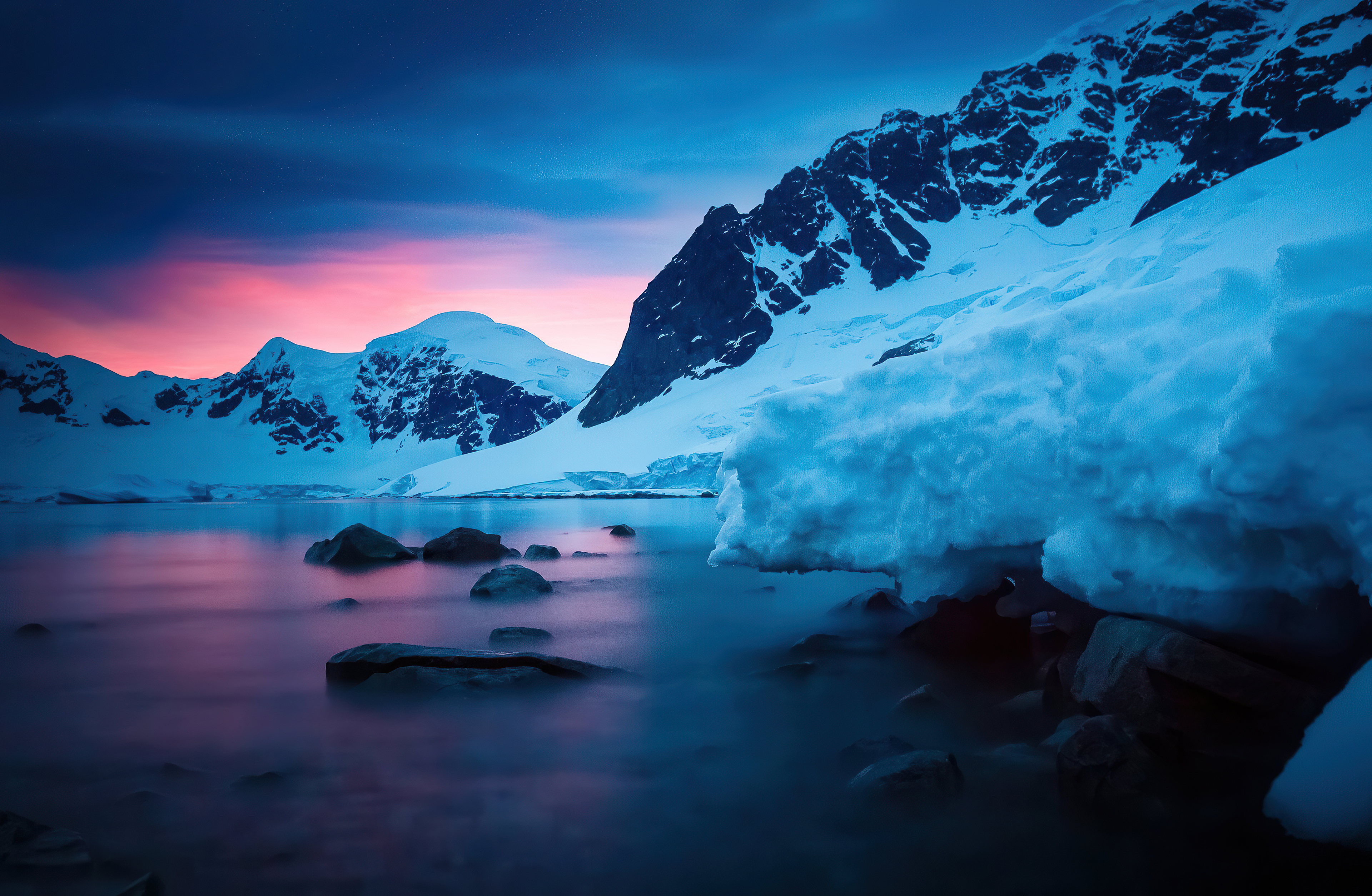 Sunset over snowy mountains and a rocky shore HD Wallpaper