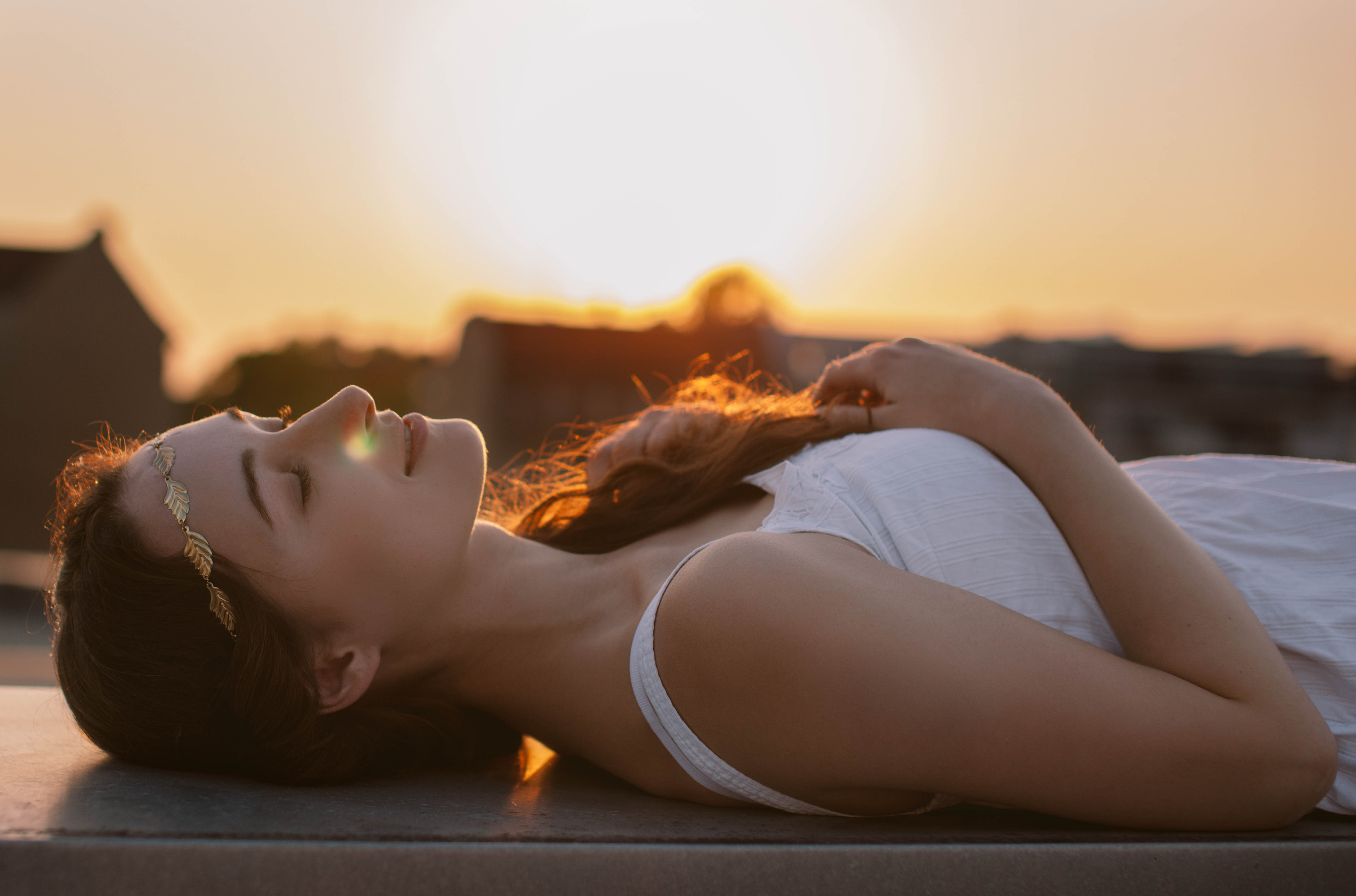 Woman with golden headband lying down at sunset HD Wallpaper
