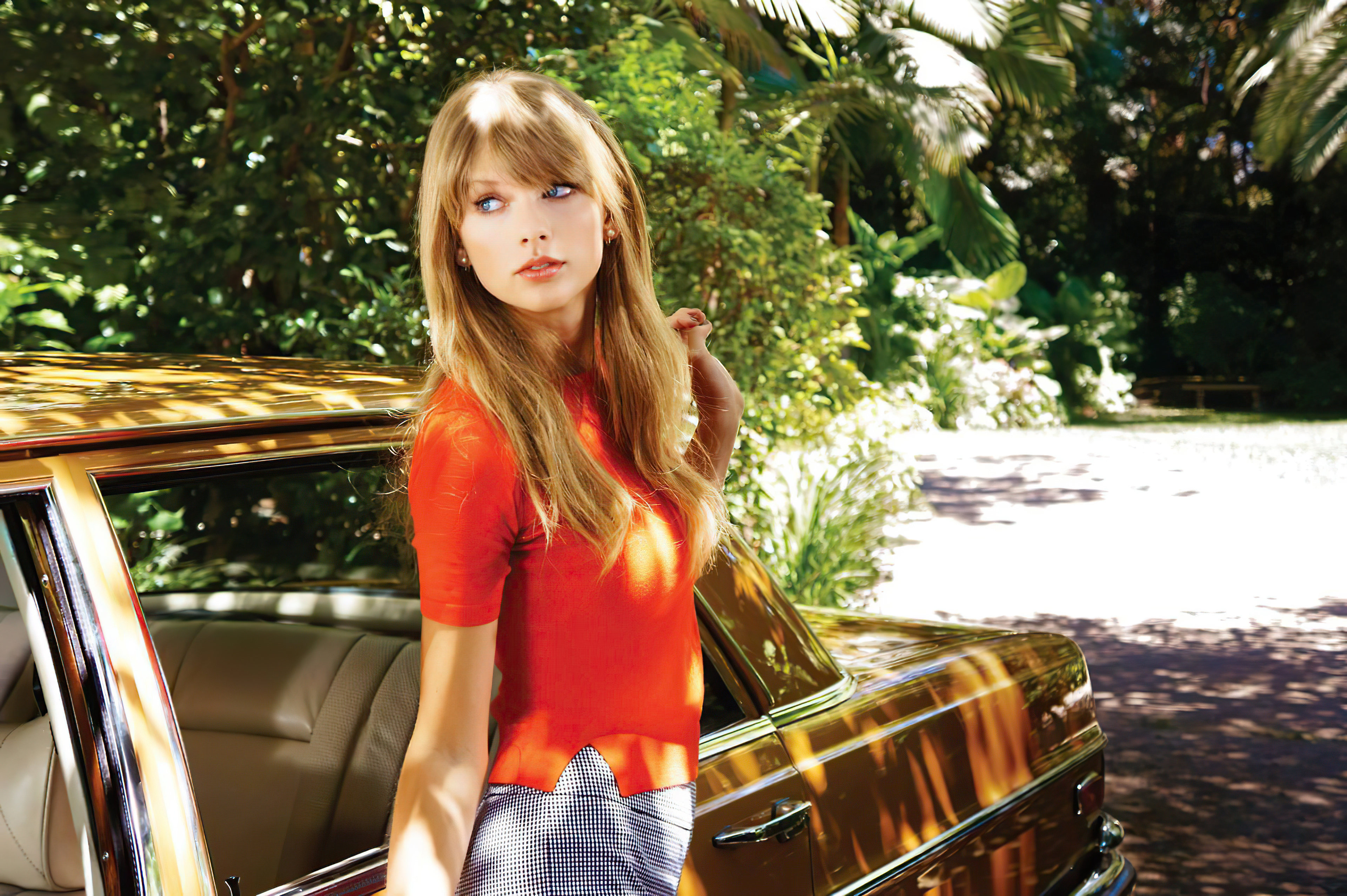 Taylor Swift in a red top and checkered skirt by a car HD Wallpaper