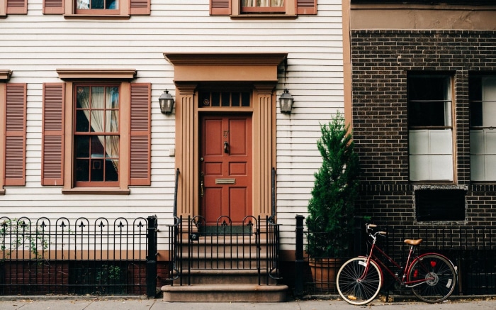 Red bicycle parked beside a house in West Village NYC