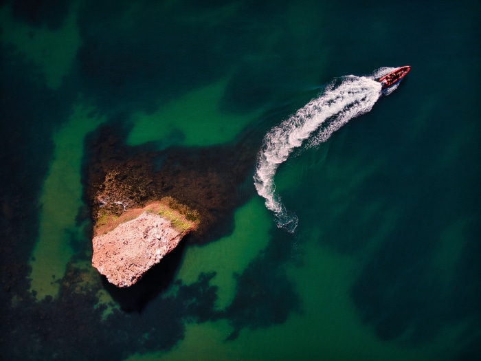 Boat on the water near a rocky island