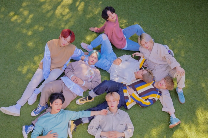 ATEEZ members lying on grass