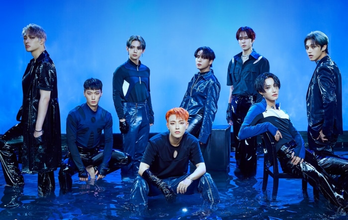 ATEEZ members posing in water