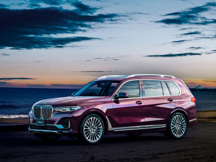 BMW X7 SUV on a beach at sunset