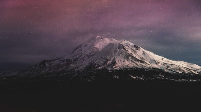 Snow-capped mountains under a starry night sky