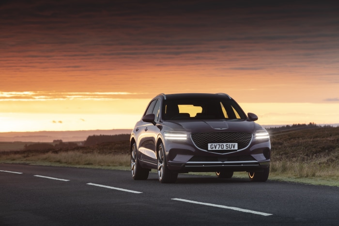 Genesis GV70 SUV on a road at sunset