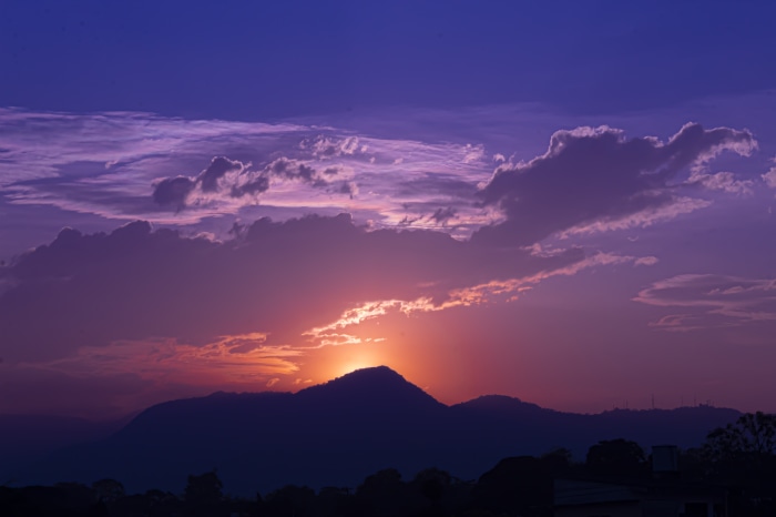 Sunset over mountains with purple clouds