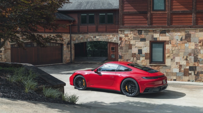 Red Porsche 911 Carrera GTS parked in front of a house