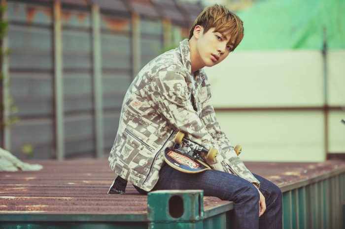Jin from BTS with a skateboard