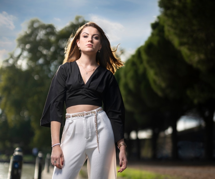 Woman in black crop top and white pants