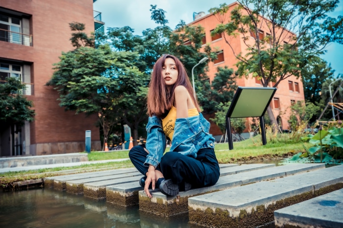 Asian woman with brunette hair sitting by water