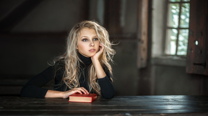 Young woman with blonde hair and a book