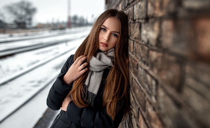 Woman in Scarf by Brick Wall and Train Tracks