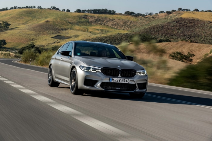 Silver BMW M5 Competition driving on a road