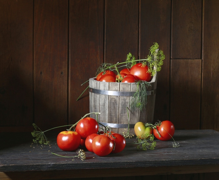 Tomatoes and dill in a wooden bucket