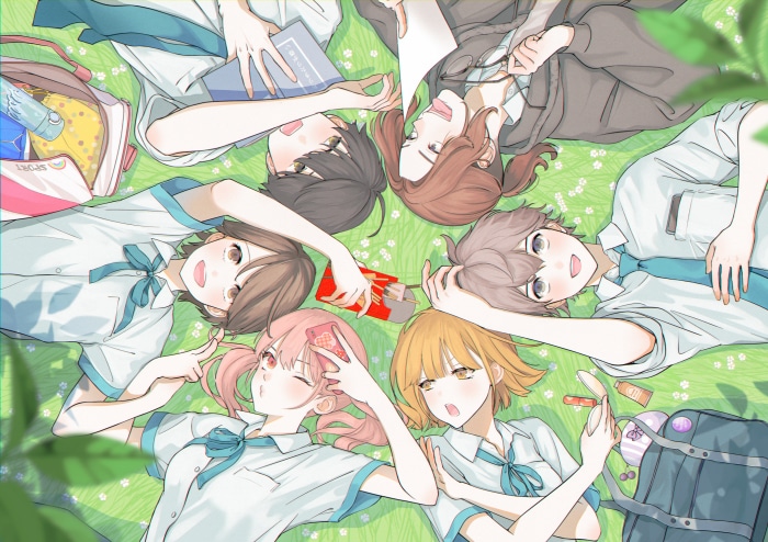 Friends lying on grass with school bags