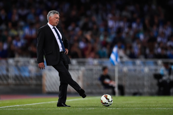 Carlo Ancelotti kicking a soccer ball on a field