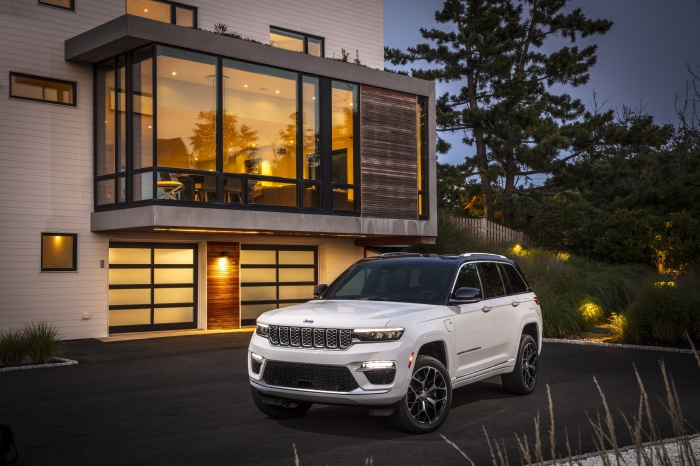 2022 Jeep Grand Cherokee Summit Reserve 4xe parked in front of modern house