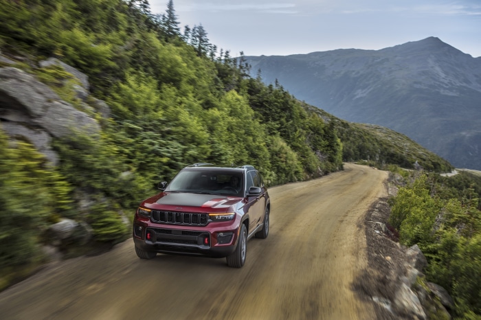 Red 2022 Jeep Grand Cherokee Trailhawk driving on a dirt road
