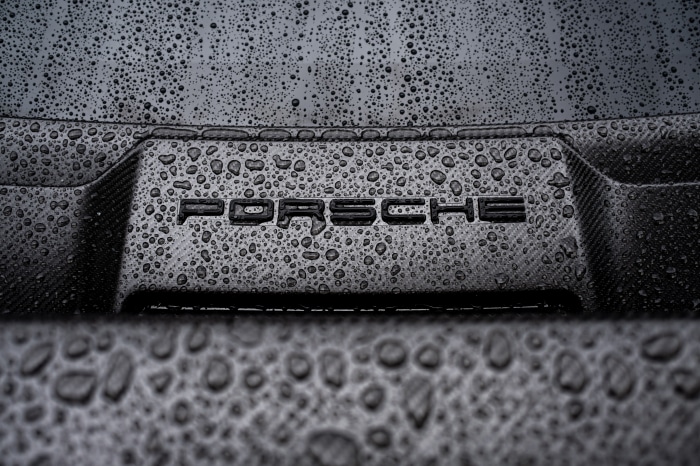Porsche logo on a car in the rain
