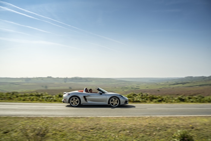 Silver Porsche Boxster Cabriolet driving on a road