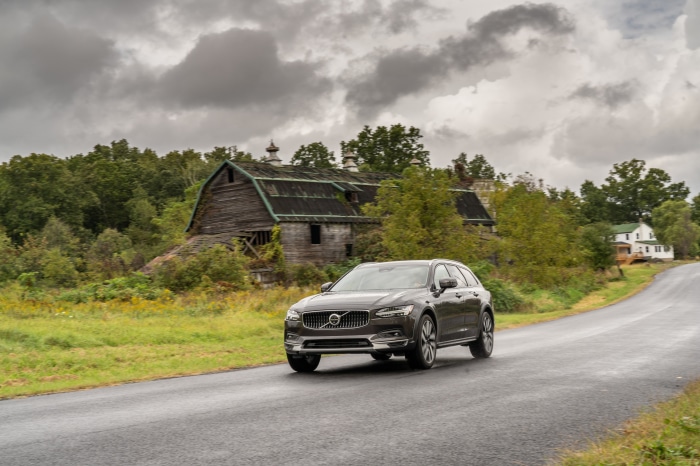 Volvo V90 B6 AWD driving past a barn