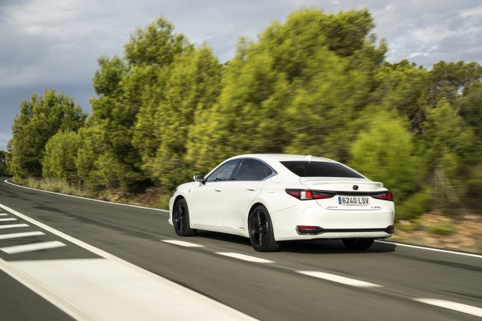 White Lexus ES 300h F SPORT driving on a road