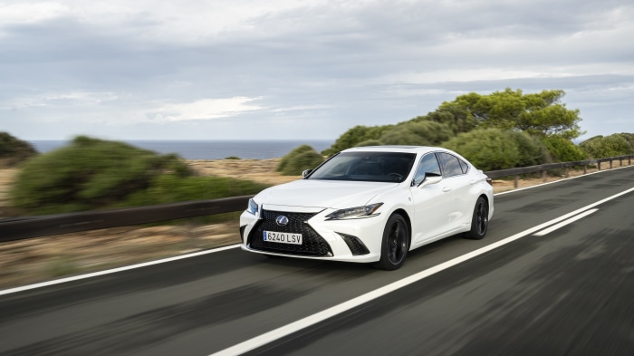 White Lexus ES 300h F SPORT driving on a coastal road