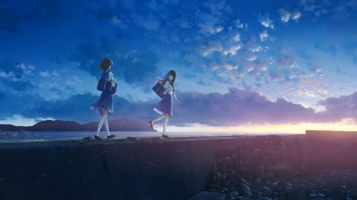 Two schoolgirls walking by the sea at sunset