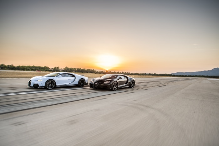 Two Bugatti Chirons on a Racetrack at Sunset