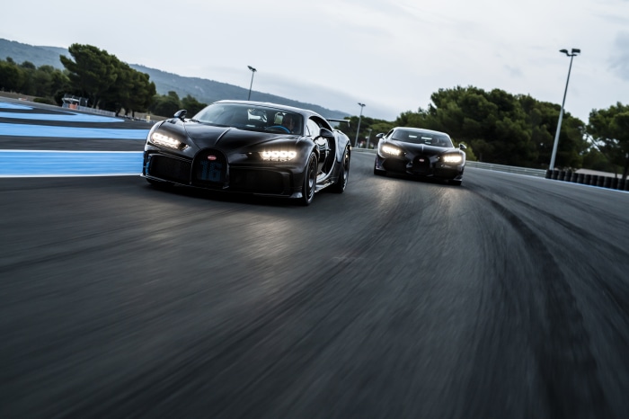 Two black Bugatti Chiron supercars on a racetrack