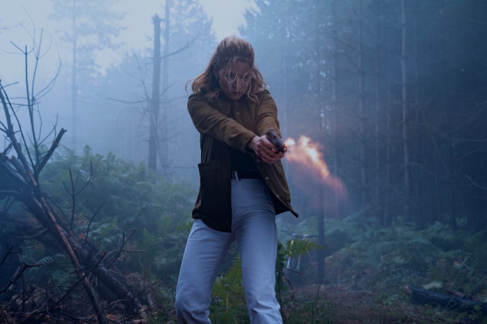 Madeleine Swann firing a gun in a forest