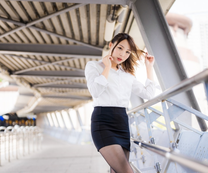Asian woman in white shirt and black skirt