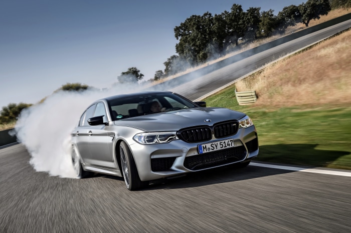 Silver BMW M5 Competition drifting on a race track