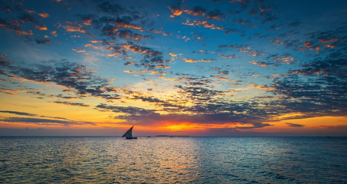 Sailboat on the ocean at sunset