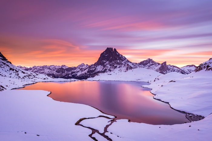 Snowy mountain lake at sunset