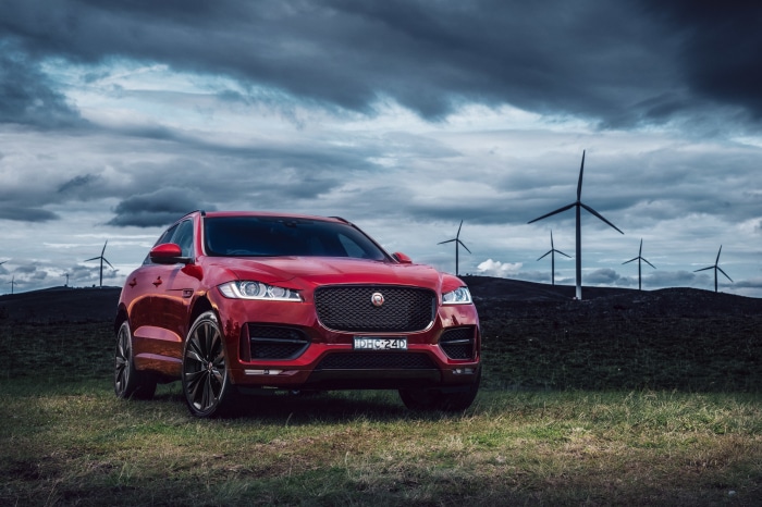 Red Jaguar F-PACE SUV with Wind Turbines