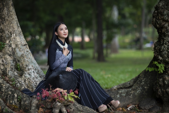 Asian woman in traditional dress with conical hat